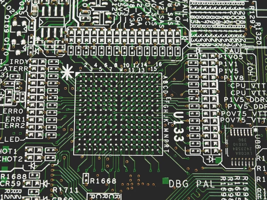 Close-up of a dark circuit board with a large chip and labeled components