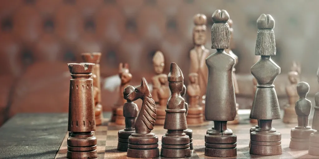 Carved wooden chess pieces on a board